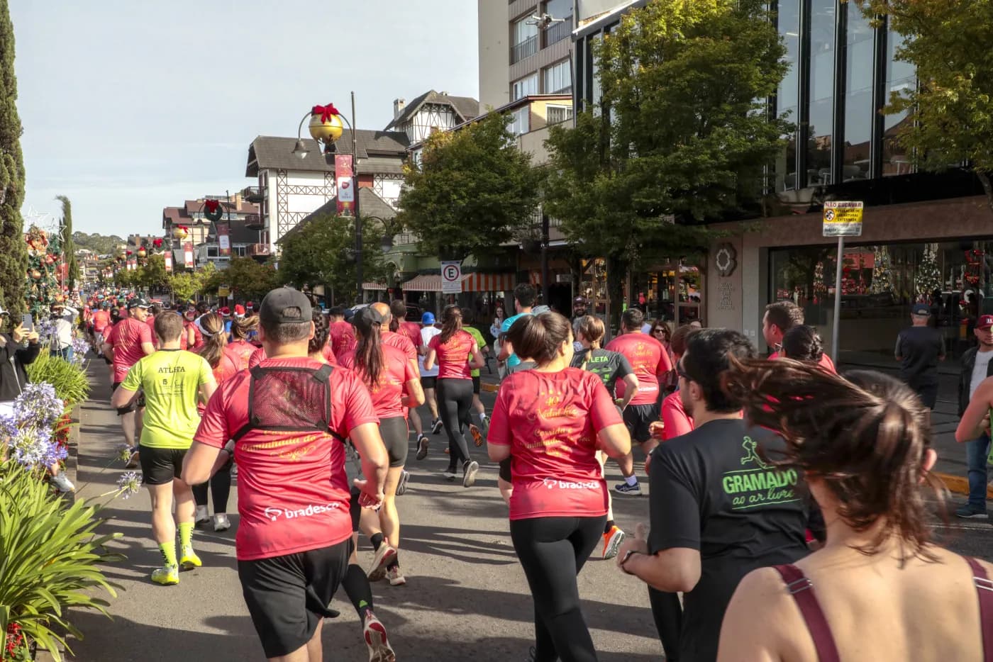 Grupo de corredores em meio ao percurso pela avenida, com a serra ao fundo.